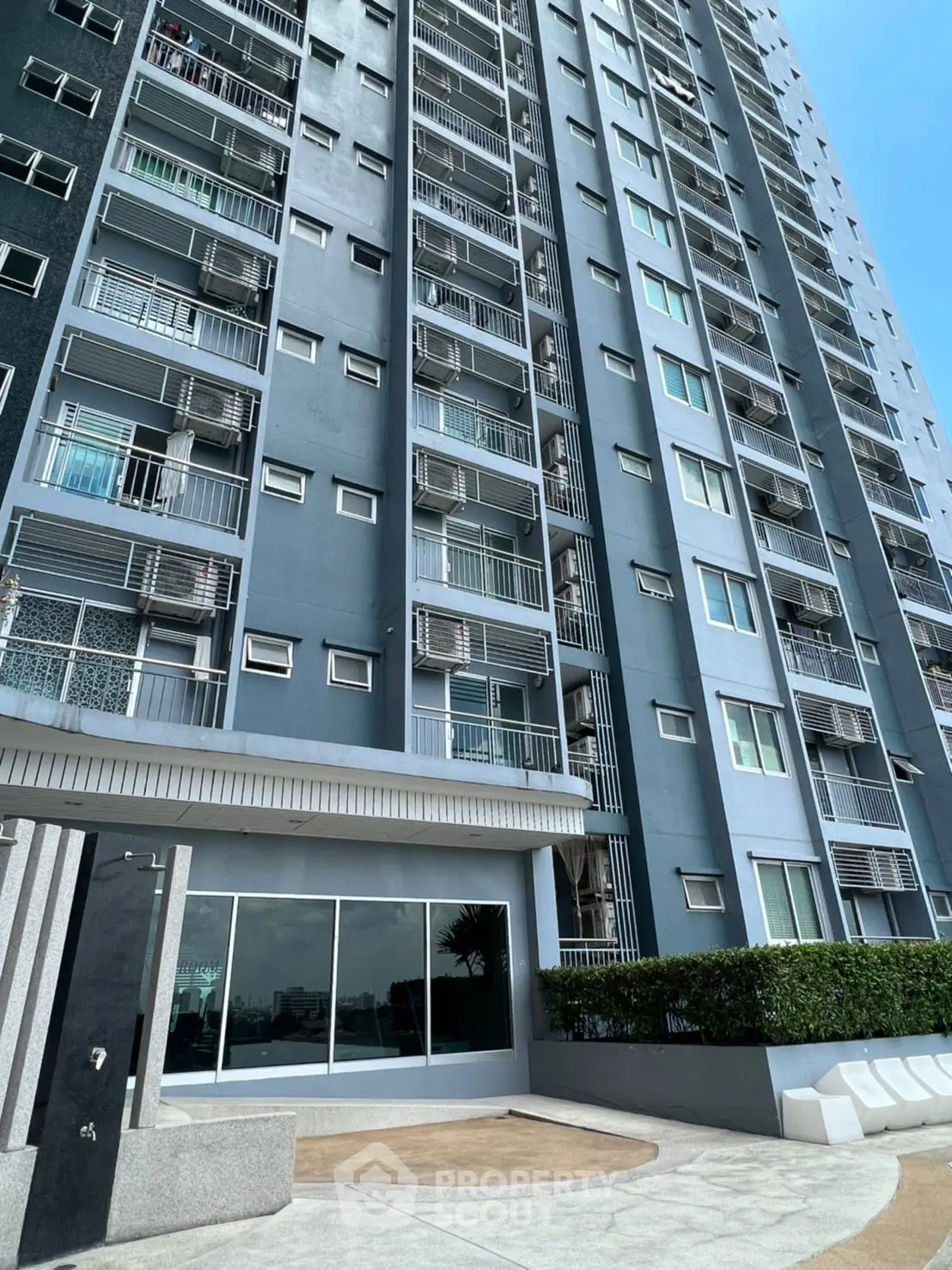 Modern high-rise building exterior with sleek design and large windows, showcasing urban living.