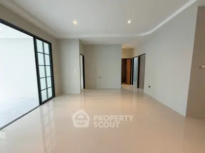 Spacious modern living room with glossy tiled floors and large windows