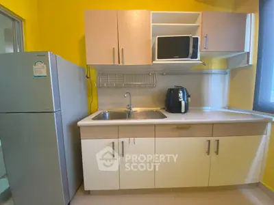 Modern kitchen with yellow walls, microwave, and spacious countertop