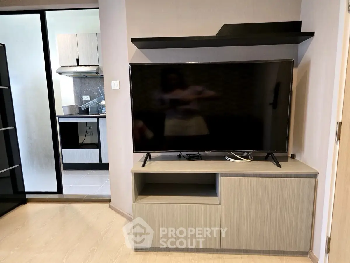 Modern living room with sleek TV stand and open kitchen layout