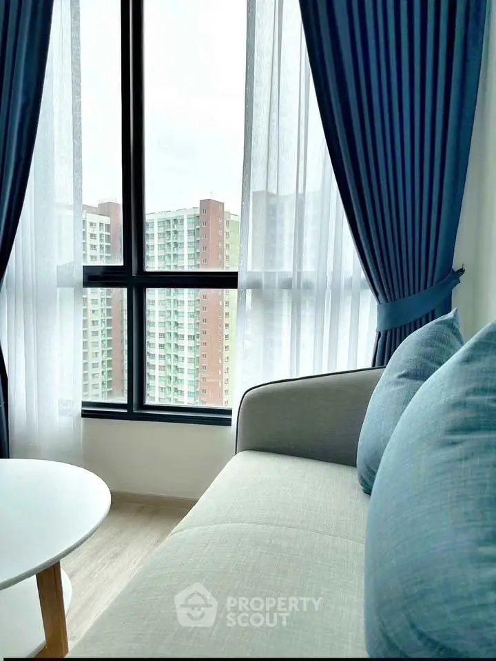 Modern living room with elegant blue curtains and city view from large window.