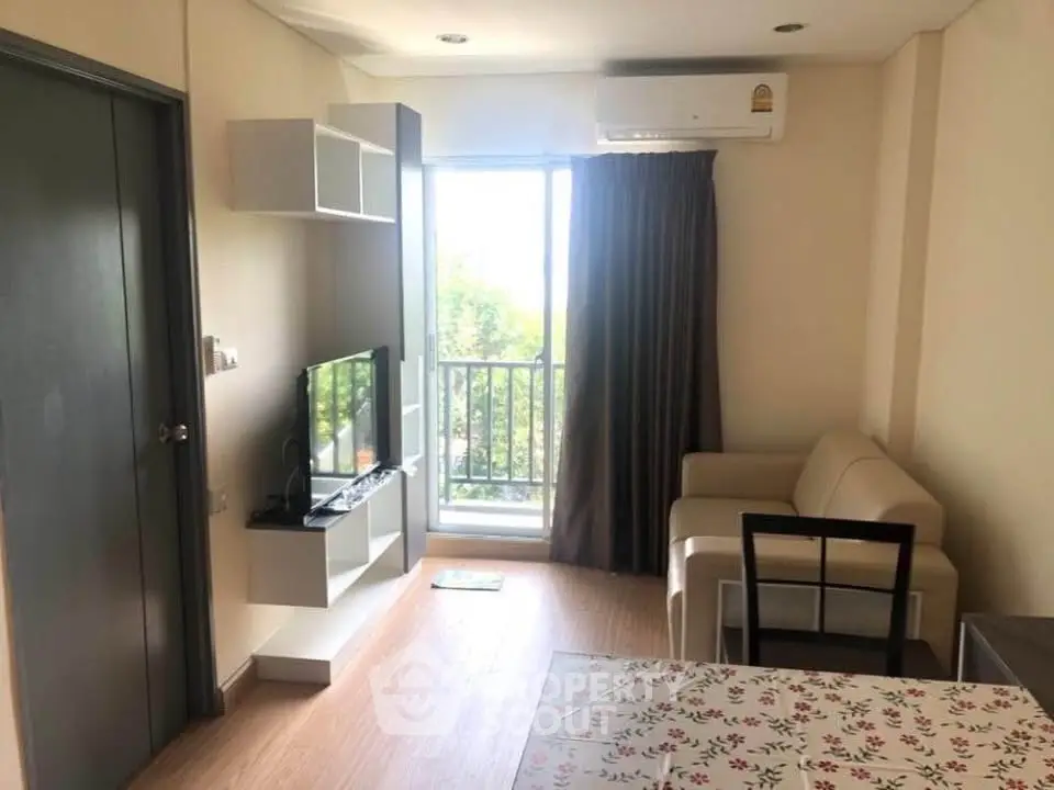 Cozy living room with modern furniture and balcony view in a stylish apartment.
