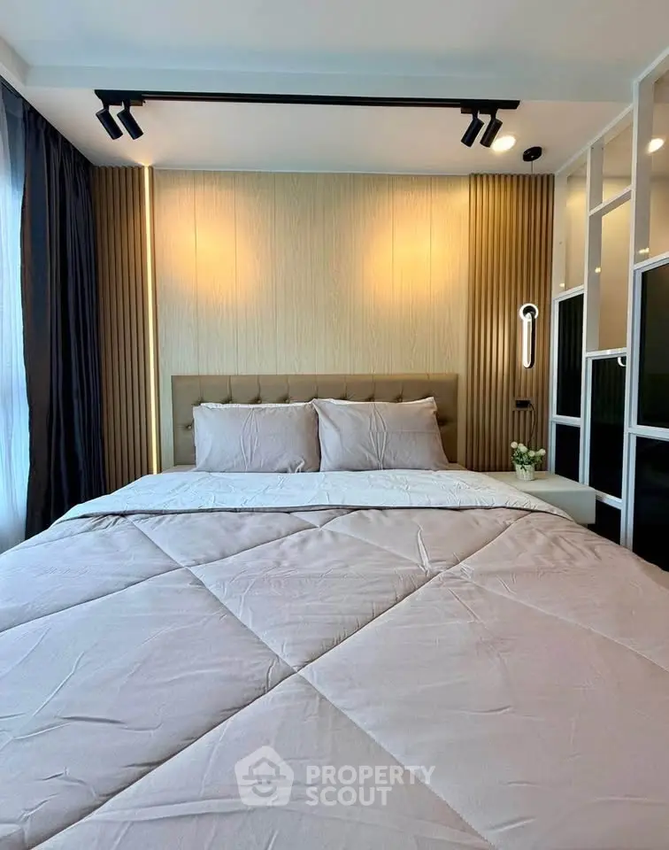 Modern bedroom with stylish lighting and cozy bedding in a contemporary apartment.