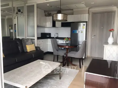 Modern open-plan living room with sleek kitchen and cozy seating area.