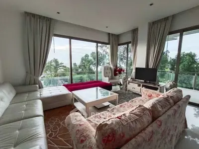 Spacious living room with large windows and lush garden view, featuring elegant furniture and modern decor.