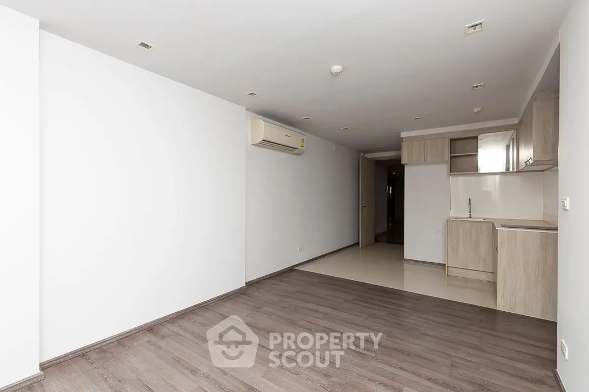 Spacious open-plan living room with modern kitchen and wooden flooring