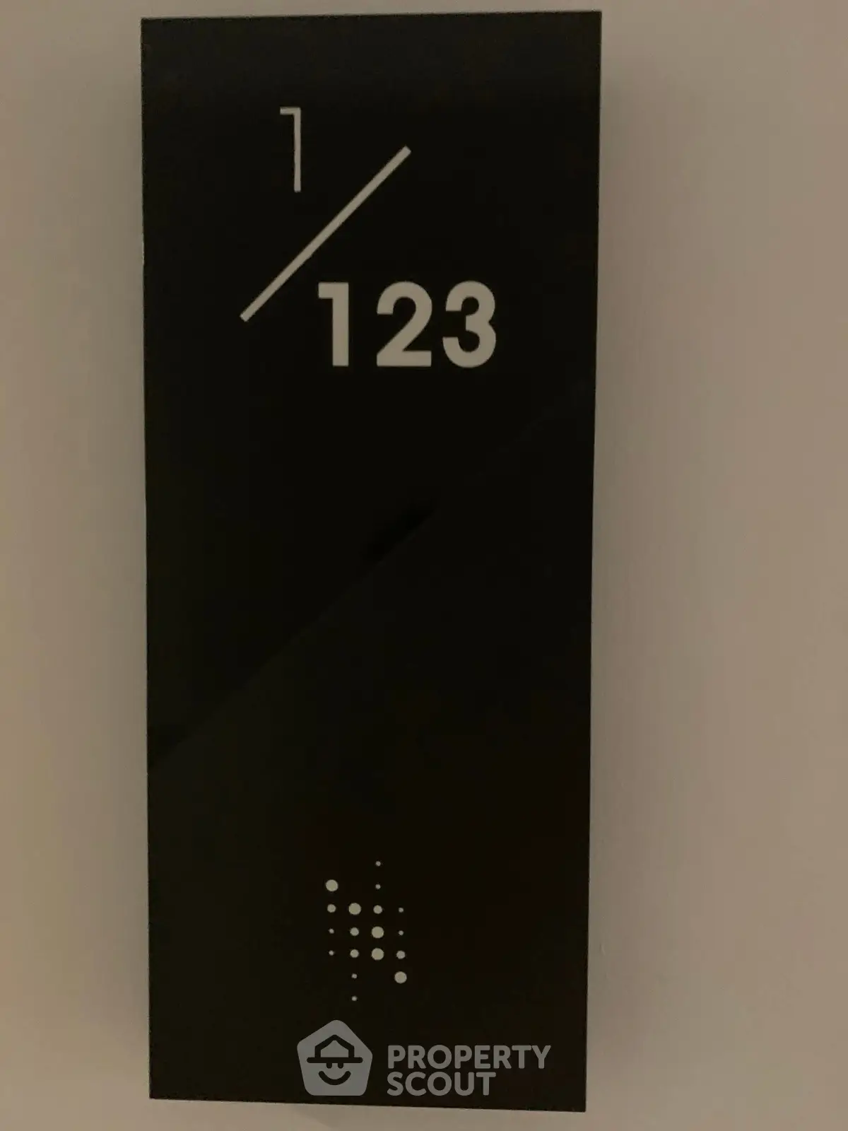 Modern apartment number sign with sleek black design and white numerals.