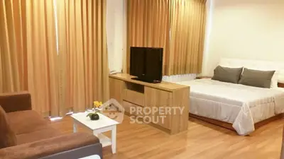 Spacious studio apartment with cozy furnishings and warm lighting, perfect for modern living.