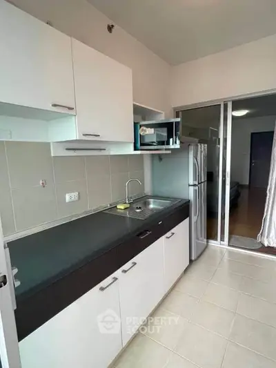 Modern kitchen with sleek cabinetry and stainless steel appliances in a contemporary apartment.