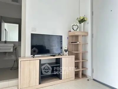 Modern living room with TV stand and open bathroom view, featuring minimalist decor and light wood furniture.
