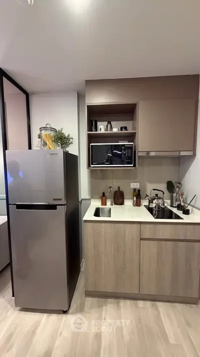 Modern kitchen with sleek appliances and stylish cabinetry in a contemporary apartment.