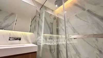 Luxurious modern bathroom with marble walls and glass shower enclosure