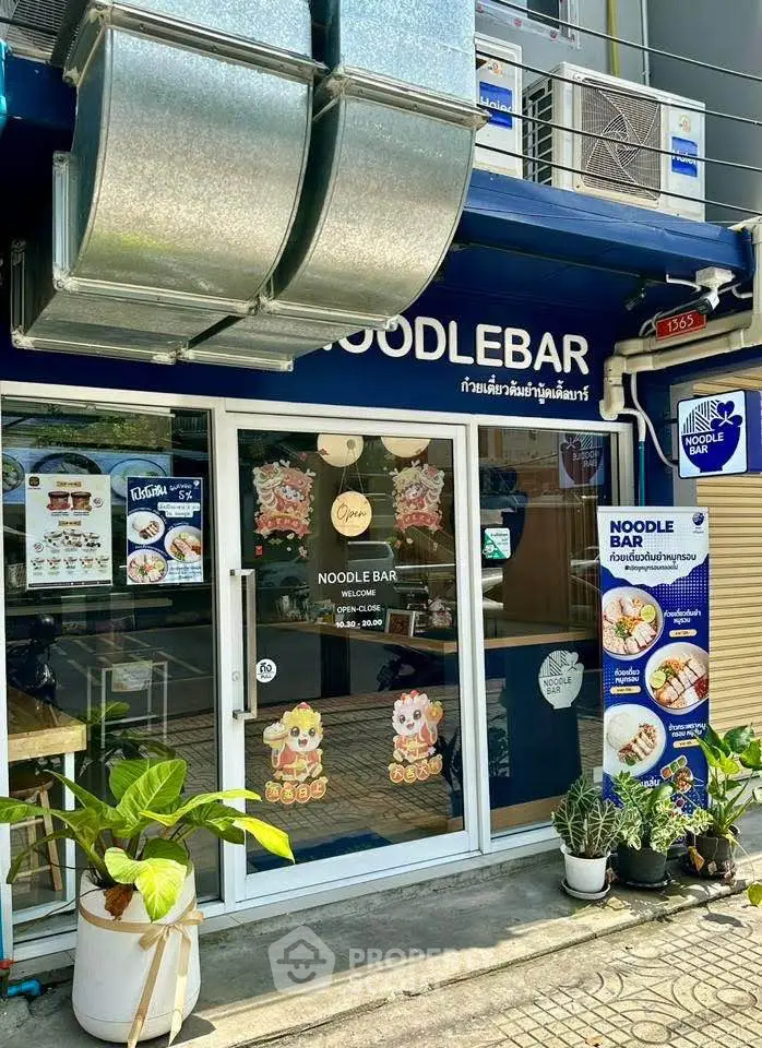 Charming noodle bar exterior with inviting entrance and vibrant signage.