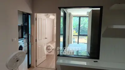 Modern apartment interior with bedroom, washing machine, and large window view.