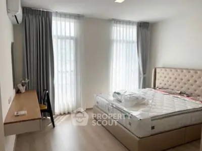 Bright and airy bedroom with modern furnishings and large windows.