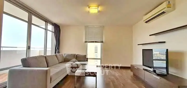 Spacious modern living room with large windows and sleek furniture