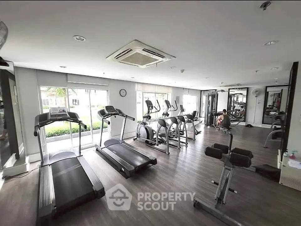 Modern gym with state-of-the-art equipment and large windows for natural light.