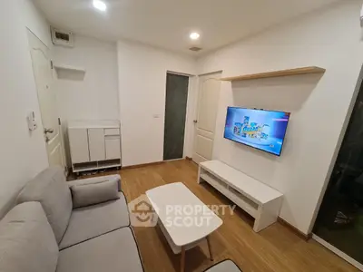 Modern living room with cozy sofa and mounted TV in stylish apartment.