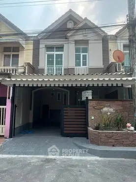 Charming multi-story home with unique architectural design and spacious driveway.