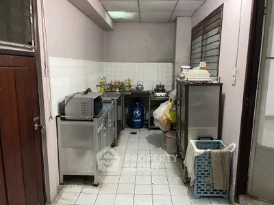 Compact kitchen with stainless steel appliances and tiled flooring