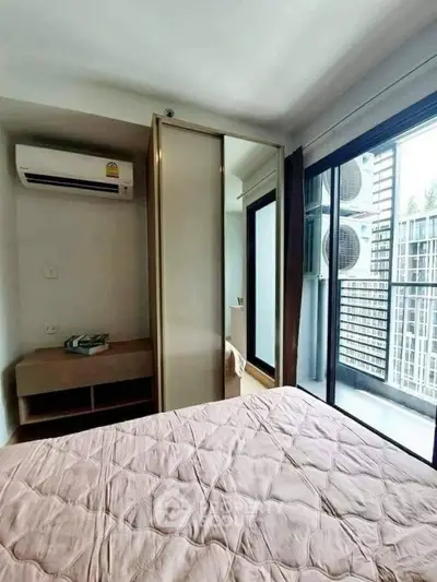 Modern bedroom with balcony access and air conditioning in urban apartment.