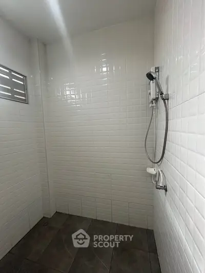 Modern minimalist bathroom with white tiled walls and shower area