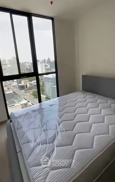 Modern bedroom with large window offering stunning city view