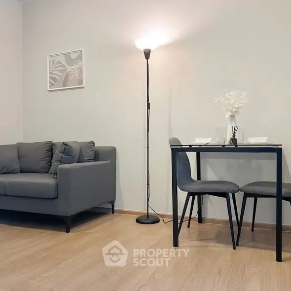 Modern living room with stylish gray sofa and dining area