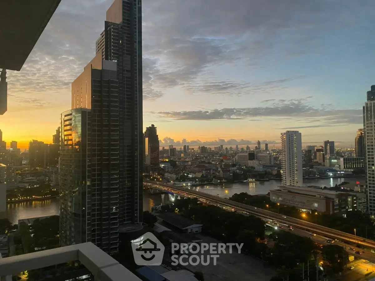 Stunning cityscape view from high-rise balcony at sunset, showcasing urban skyline and river.