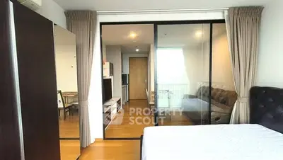 Modern bedroom with sliding glass doors leading to a cozy living area