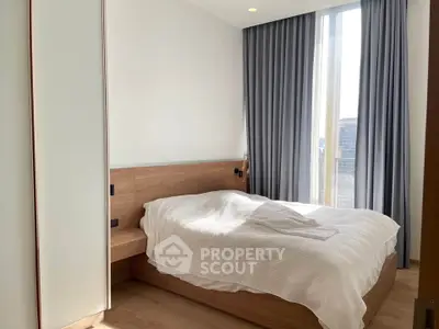 Modern bedroom with large window and elegant curtains in a stylish apartment.