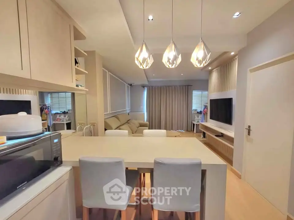 Modern living room with stylish lighting and open kitchen layout