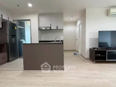 Modern open-layout kitchen and living area with sleek appliances and stylish decor.