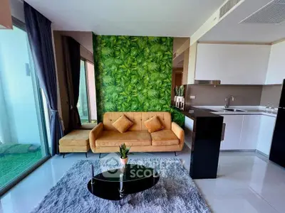 Modern living room with vibrant green accent wall and sleek kitchen design.