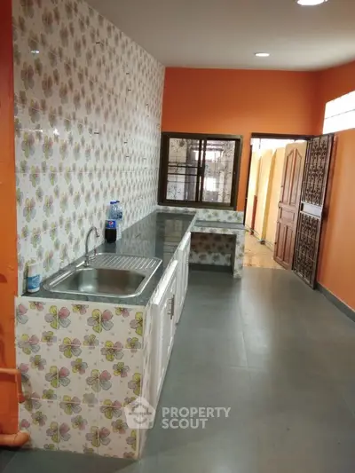 Charming kitchen with colorful butterfly tiles and sleek countertops.