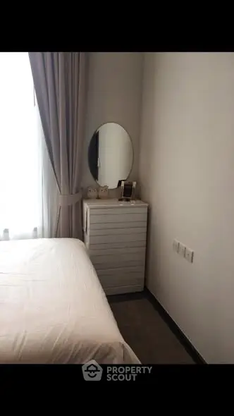 Cozy bedroom corner with elegant dresser and round mirror