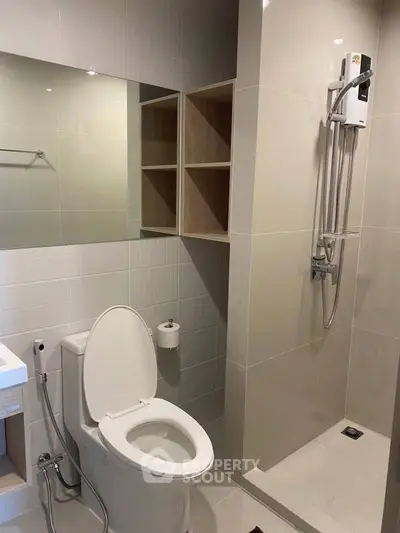 Modern bathroom with shower and toilet in sleek minimalist design.