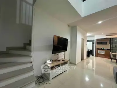 Modern living room with sleek TV setup and open layout, showcasing contemporary design and spaciousness.