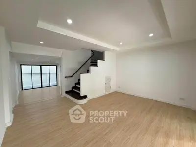 Spacious modern living room with wooden flooring and elegant staircase
