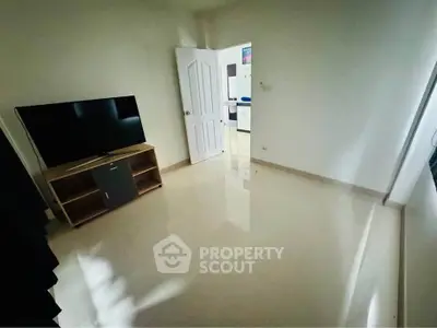 Spacious room with glossy floor and TV stand, ideal for modern living.