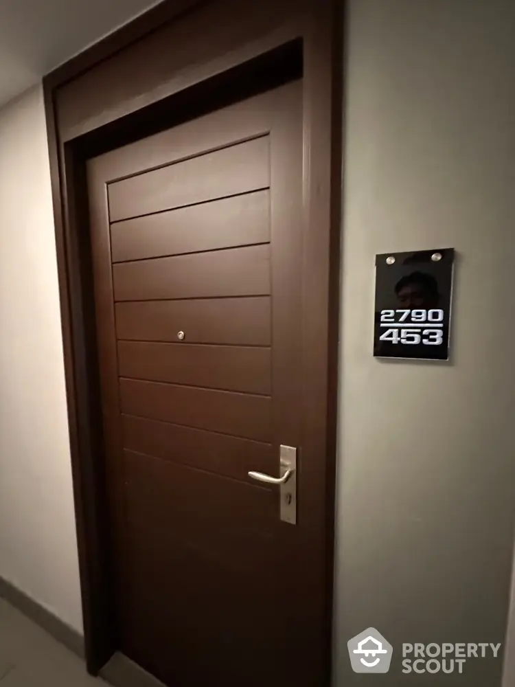 Modern apartment door with sleek design and room number plaque