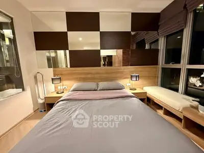 Modern bedroom with stylish decor and large windows offering natural light.