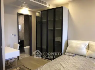 Modern bedroom with sleek wardrobe and ensuite bathroom in luxury apartment