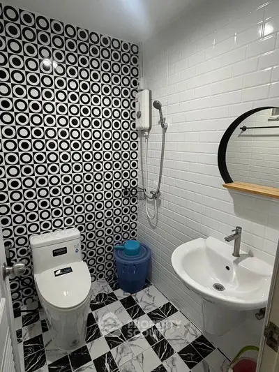 Modern bathroom with stylish black and white tile design and round mirror