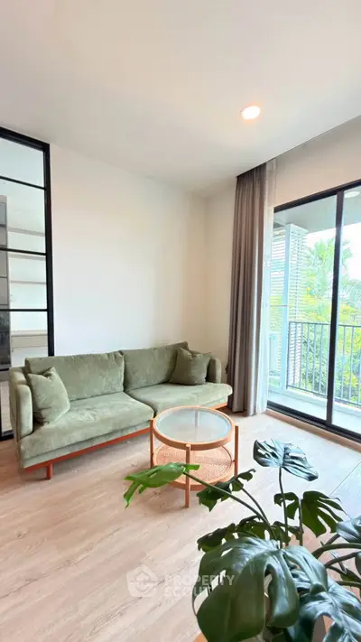 Modern living room with green sofa, glass doors, and balcony view in stylish apartment.