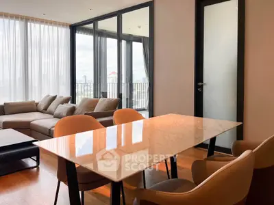 Spacious modern living room with large windows and city view, featuring elegant furniture and a dining area.