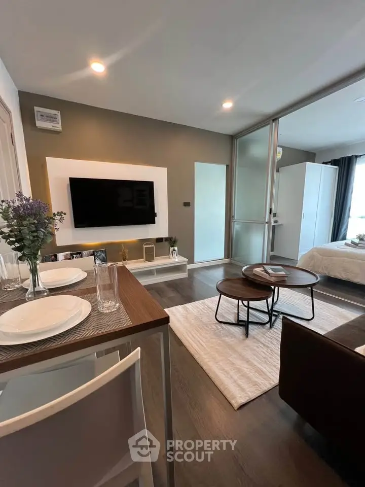 Modern open-plan living room with stylish decor and wall-mounted TV