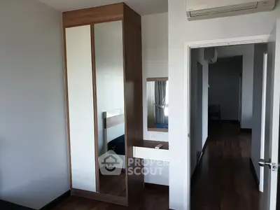 Modern bedroom with sleek wooden wardrobe and air conditioning