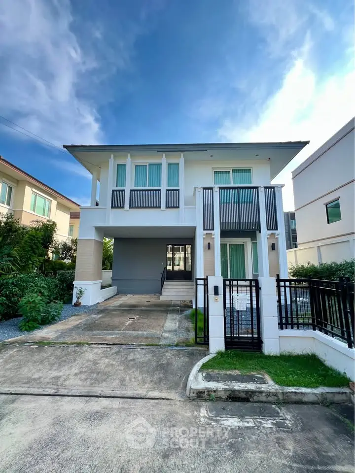Modern two-story house with sleek design and spacious driveway in a serene neighborhood.