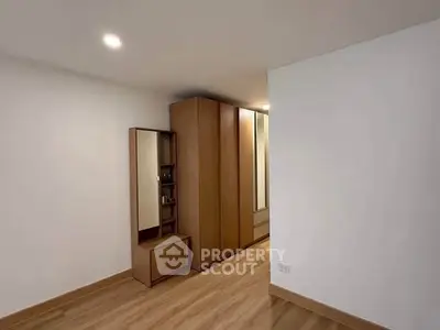 Spacious bedroom with modern wooden wardrobe and sleek flooring